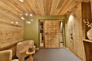 Un interior de madera con un sofá, una mesita y una puerta.