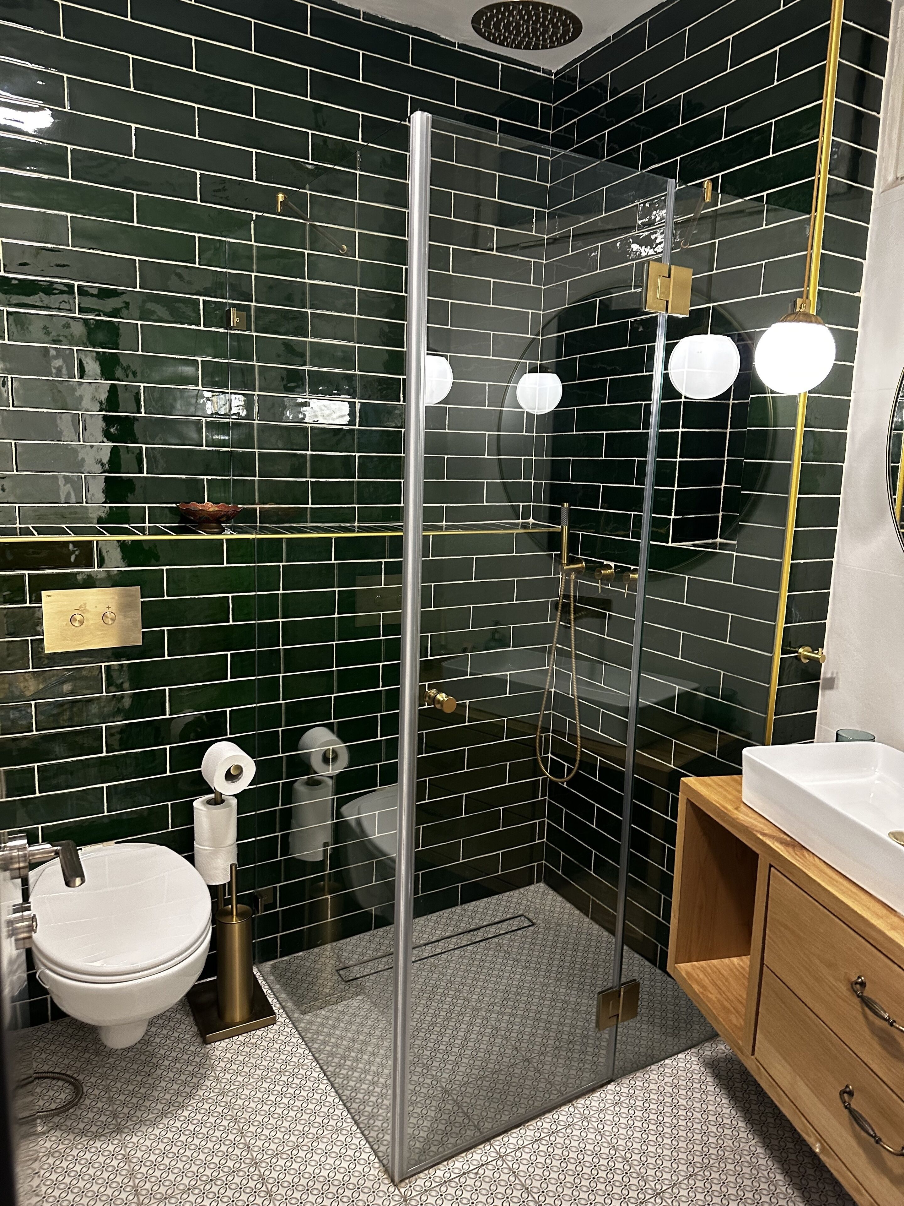 Une salle de bain moderne avec une douche à parois de verre, des toilettes blanches et un meuble-lavabo en bois.