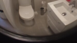 Un bagno con il water, un lavandino e uno specchio.
