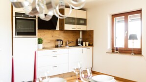 Eine moderne Küche mit weißen Schränken, einer Holz Arbeitsplatte und einem Fenster mit Blick.