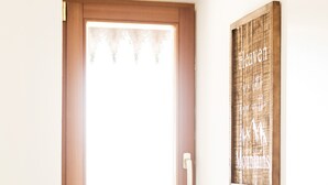 Ein Zimmer mit Holztür, weißem Krug und kleinem Tisch.