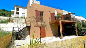 A two-story building with a balcony and a staircase leading to the upper floor.
