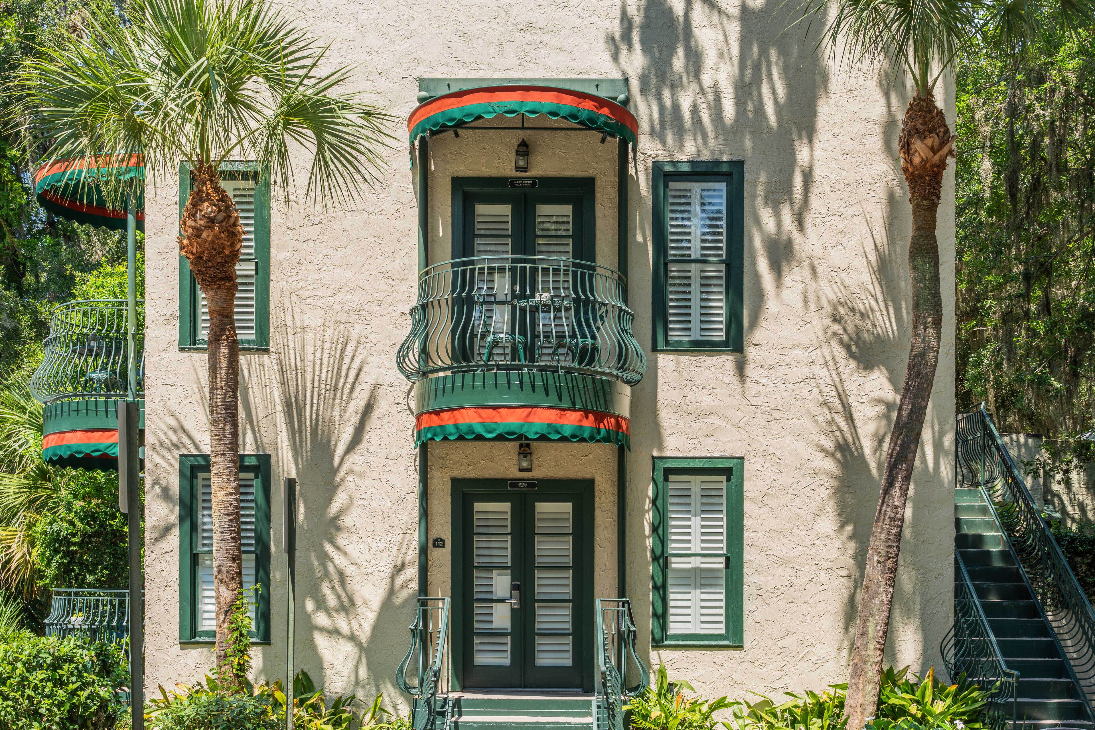 A building with a balcony, a staircase, and a door.