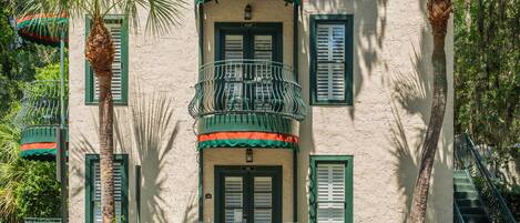 A building with a balcony, a staircase, and a door.