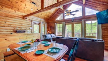 Enjoy meals in this cozy dining area with a large table, comfortable sofa, and TV.
