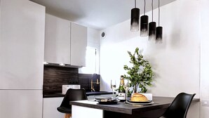 A modern kitchen with a central island, black bar stools, and pendant lighting. - 5min Palais, Luxury&Cinema Studio,Croisette,Forville,beaches (Cannes)