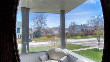 Ett takförsett utomhusområde med sittplatser och utsikt över ett bostadsområde.
