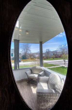 Un espacio de estar techado al aire libre con vista a un barrio residencial.