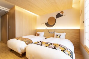 A hotel room with two beds, wooden flooring, a wooden ceiling, and a wall-mounted artwork.