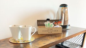 A wooden bar area with a coffee station, including cups, a coffee pot, and a box of biscotti. - Tranquil retreat close to beach Taormina. Double room in 1800's casale with pool (Mascali)