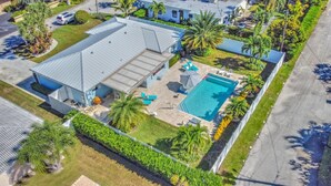 A residential property with a swimming pool, a covered patio, and a well-maintained garden.