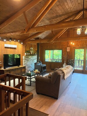 Un intérieur en bois avec une cheminée, un téléviseur et un coin salon.