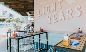 A restaurant area with a sign reading "Welcome to LIGHT YEARS HOTEL". - Bnbbooking - Burleigh Oasis, heated Spa (Gold Coast)