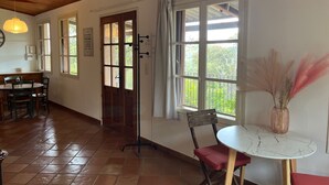 A dining area with a wooden ceiling, tiled floor, and a table with chairs. - Maison Individuelle au Cœur du Maquis Corse (Porto-Vecchio)