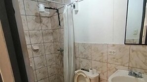 Casa de banho com sanita, lavatório e chuveiro.