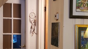 A hallway with a wooden bench, a door with frosted glass panels, and artwork on the walls. - Mountain Bliss is a quiet mountain retreat, sleeps 6, hot tub, pet friendly (Evergreen)