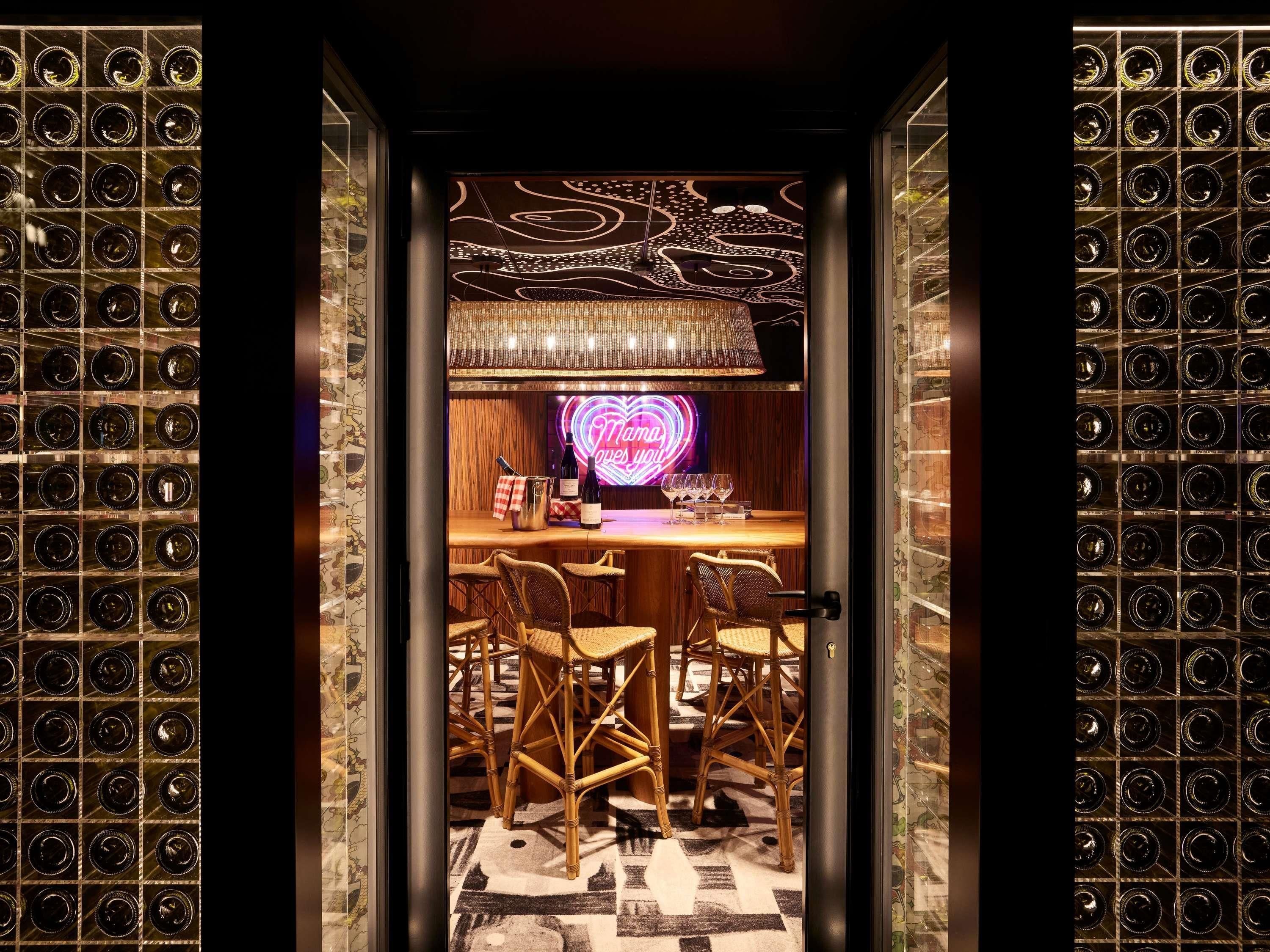 A room with a bar area, wicker chairs, and a patterned floor.