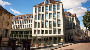 A multi-story building with large windows, a flat roof, and a sign that reads 'HOTEL.'