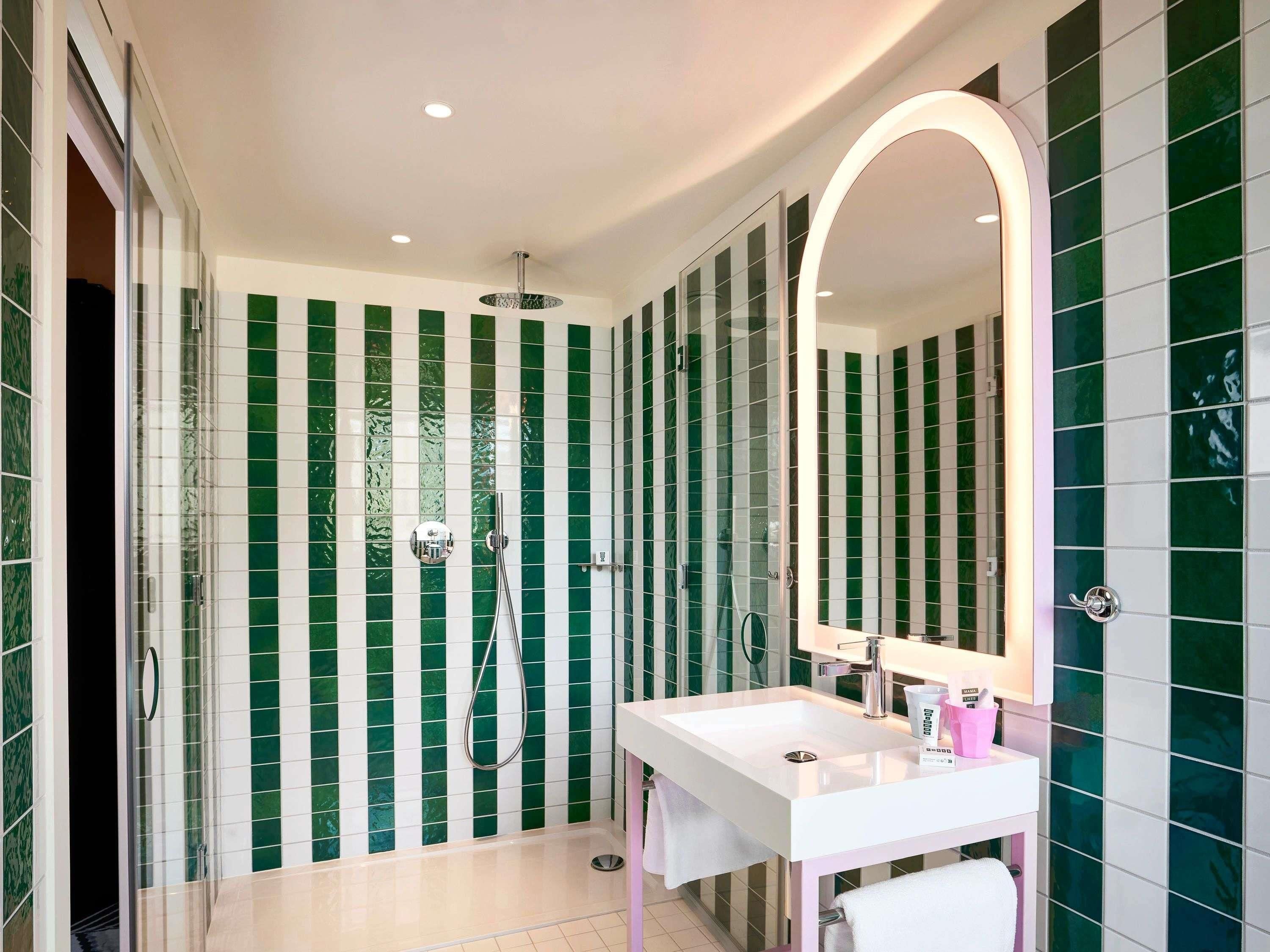A modern bathroom with a shower, a sink, and a mirror.