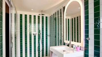 A modern bathroom with a shower, a sink, and a mirror.