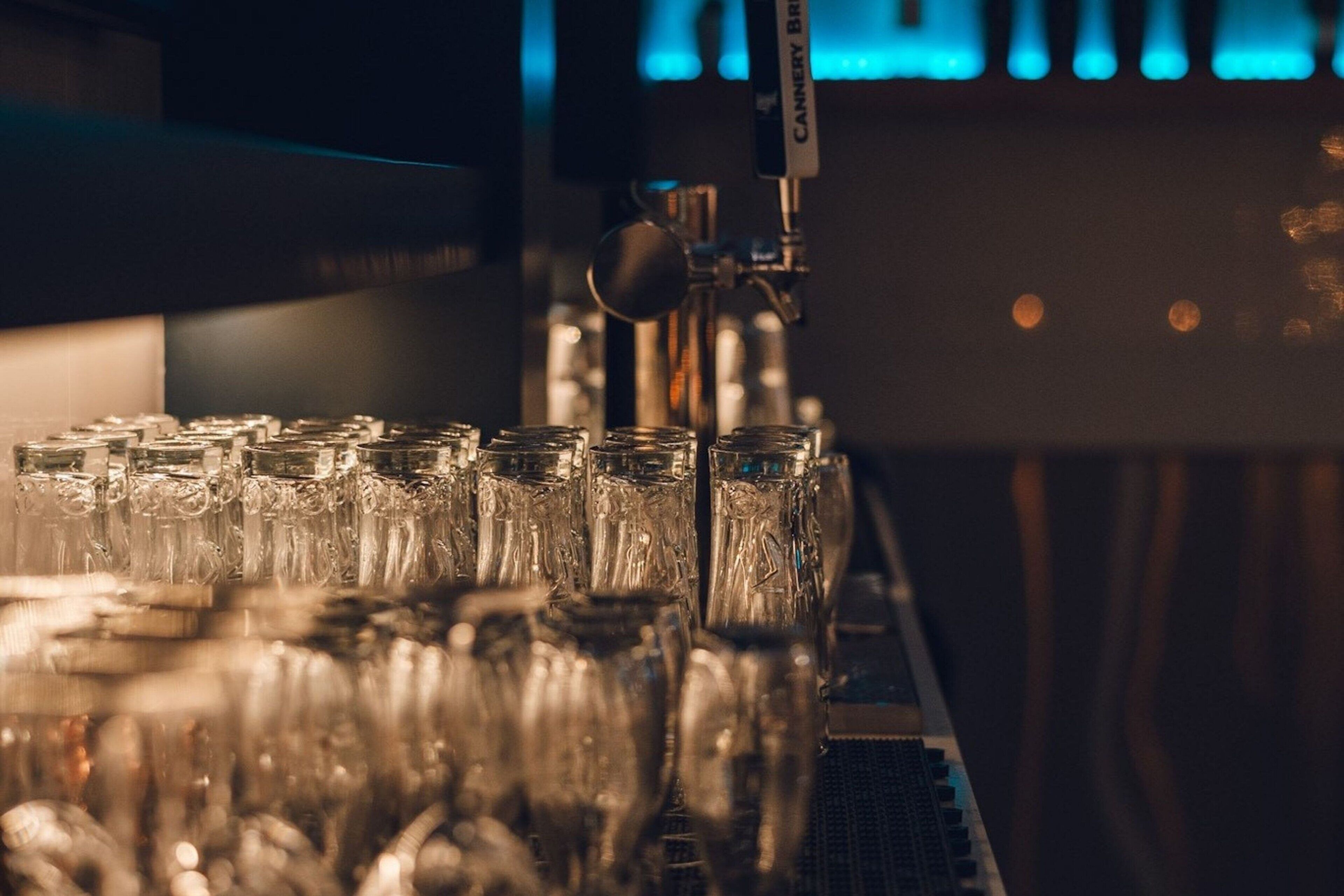 A bar area with a tap labeled "CANNERY BRIE" and a row of empty glasses on a counter.