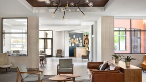A spacious lobby with a reception desk, seating area, and large windows.