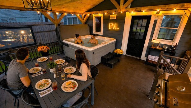 Un espace repas avec un jacuzzi, un plafond en bois et un néon.