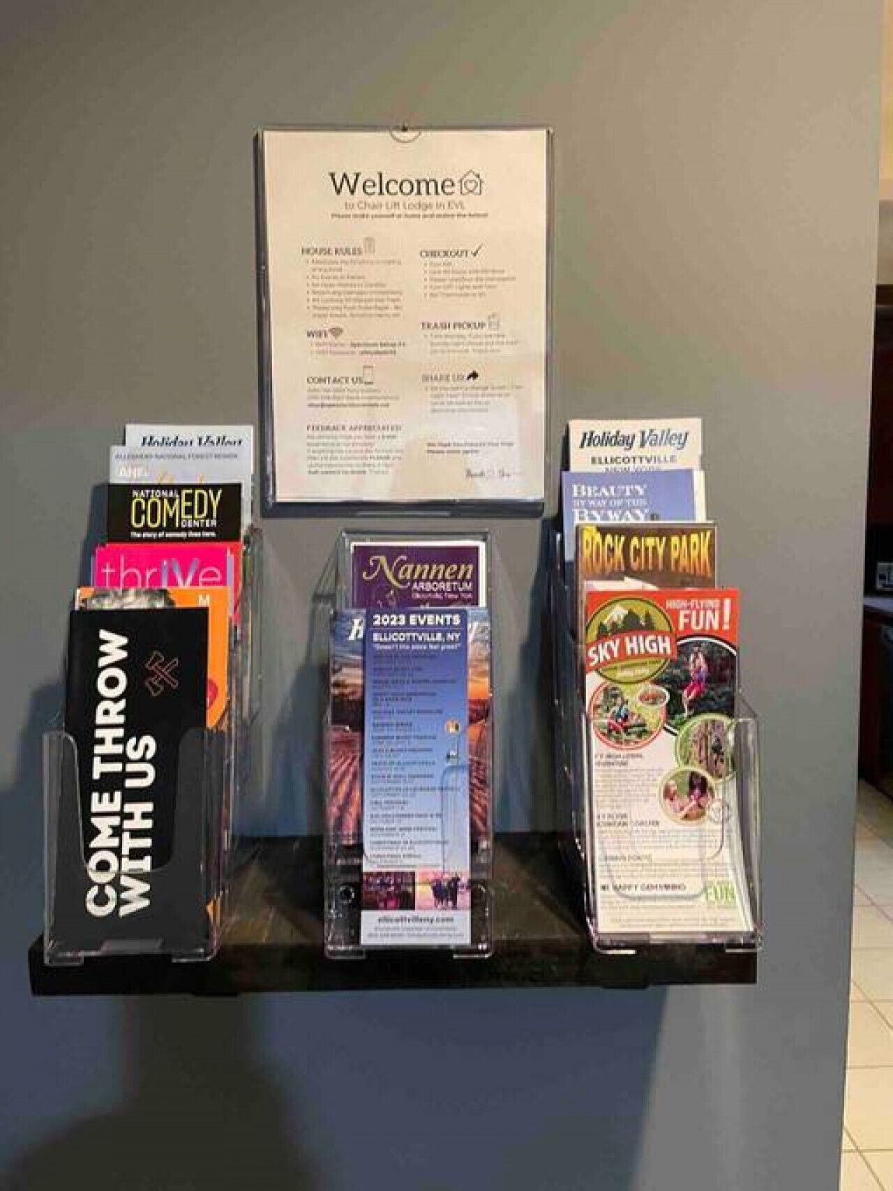 A welcome sign with event brochures for 2023 in Ellicottville, NY.