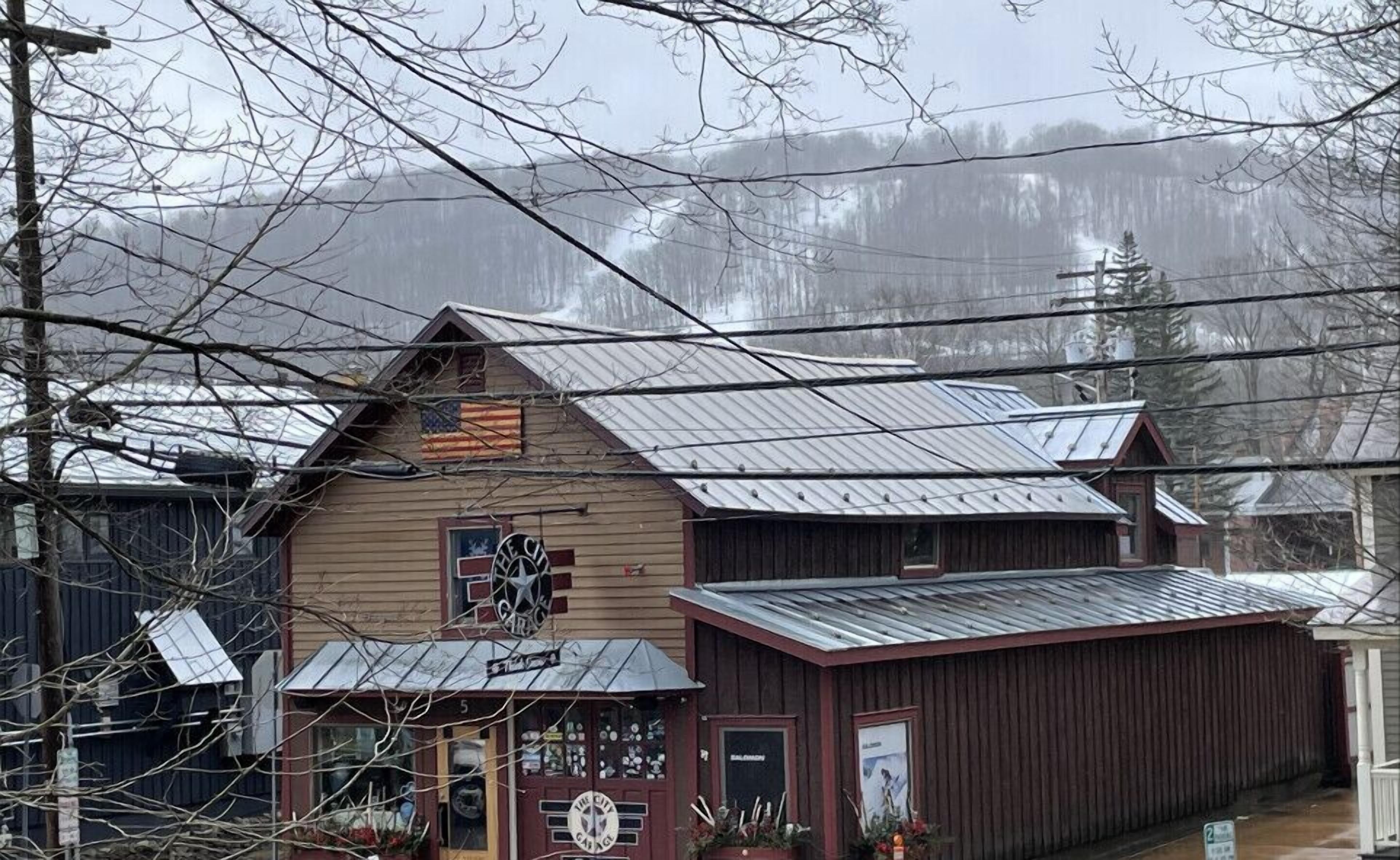 A rustic building with a metal roof and a sign that reads "The City Garage."