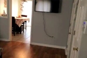 Comfortable room with a television and doorway to a separate area.