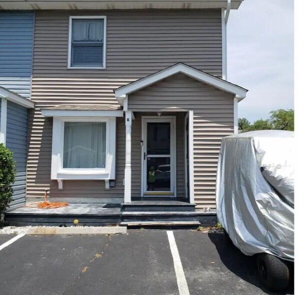 Guests enter through the front door into a simple, functional building with a flat roof and a small porch area.