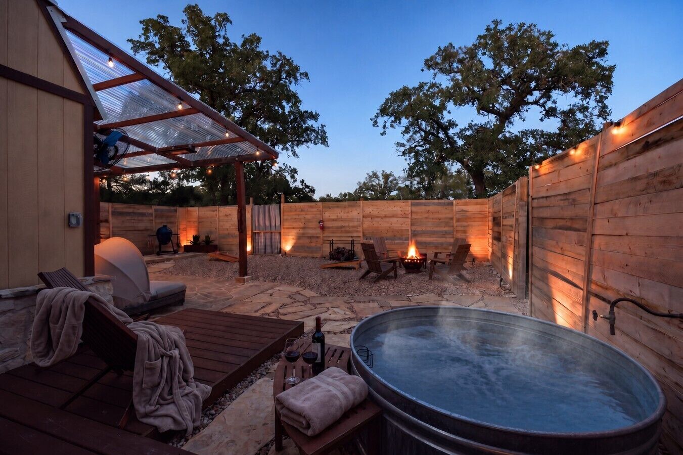 An outdoor patio area with a hot tub, seating, and a fire pit.