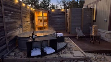 An outdoor hot tub area with seating and a wooden deck.