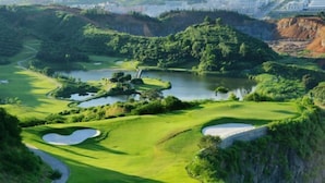Un campo da golf con bunker, ostacoli acquatici e un ponte.