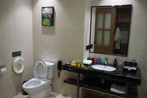 Un baño con inodoro, lavabo, espejo y dispensador de papel higiénico.