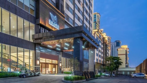 Un hotel moderno con un ingresso evidente, ampie finestre e una facciata ben illuminata.