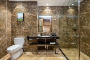 A bathroom with a toilet, sink, and shower.