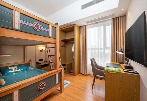A hotel room with a bunk bed, a desk with a chair, a TV, and a wardrobe.