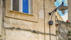 Ein Steinhaus mit einer grünen Tür und einem Fenster darüber.