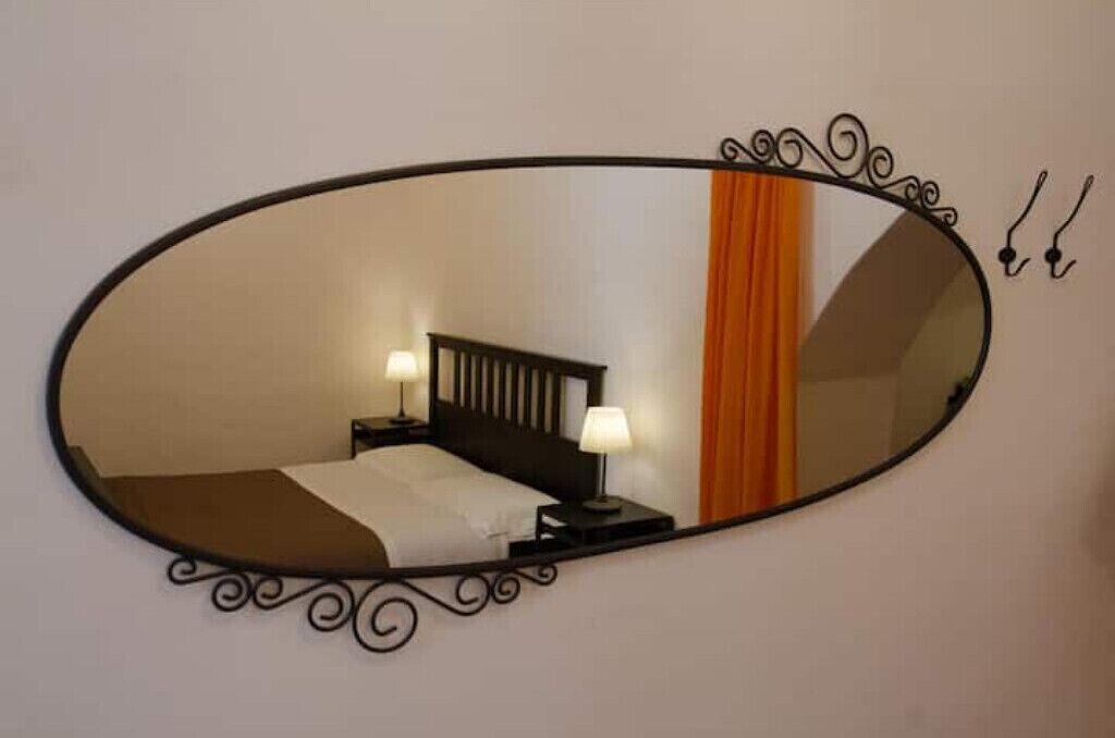 Ein Schlafzimmer mit einem Bett, Nachttischen und einem Spiegel.