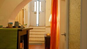 Une pièce comprenant une table à manger, une chaise, une lampe et un escalier menant à une porte.