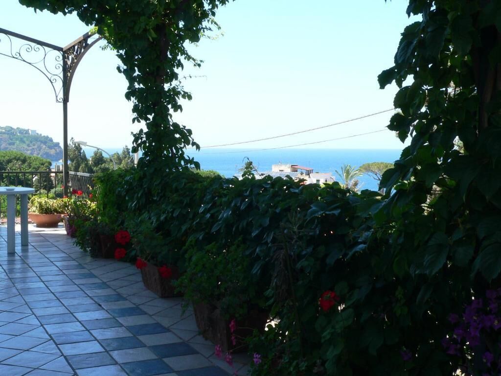 Un patio con baldosas y vistas al mar y las colinas.