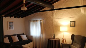 Una stanza accogliente con un divano, una poltrona e un tavolino con una lampada.