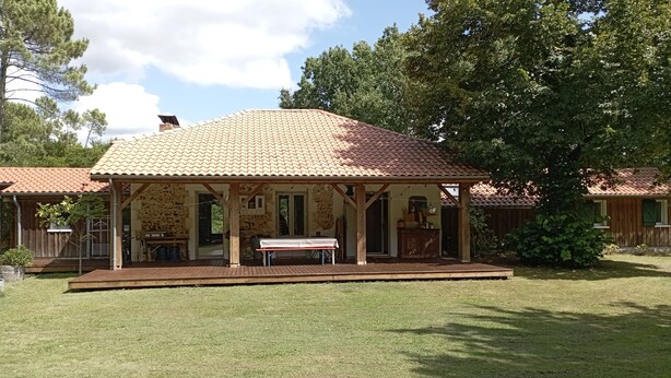 A two-story house with a tiled roof, a covered porch, and a grassy yard. - Maison Landaise Rénovée au Milieu de 2 Hectares (Sanguinet)