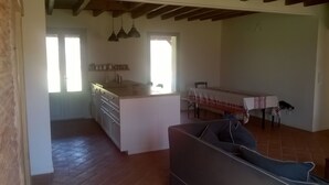 A spacious living area with a kitchen, dining table, and a sofa. - Maison Landaise Rénovée au Milieu de 2 Hectares (Sanguinet)