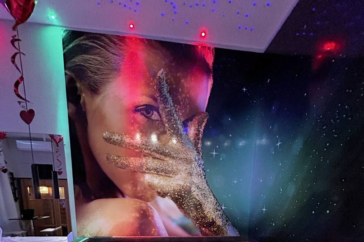 A spa tub with a starry night backdrop and a large poster of a woman.