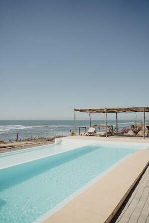 Piscine extérieure, parasols de plage, chaises longues
