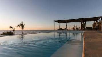 Alberca al aire libre, sombrillas en la alberca y camastros