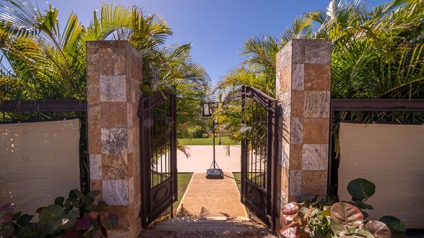 A gated entrance with a pathway leading to a lawn, surrounded by palm trees and plants. - CASA CANAVERAL-TropicalPrivatePool-14Family-sized! Near Rafael Hernandez Airport (Isabela)