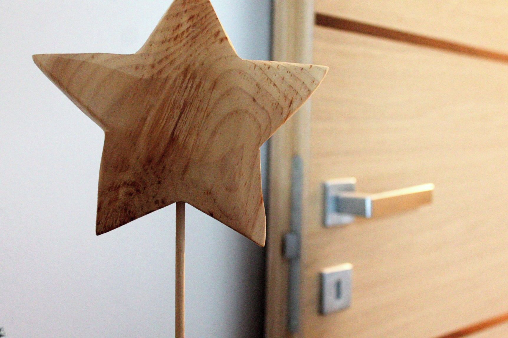 A wooden star-shaped decoration on a door handle.